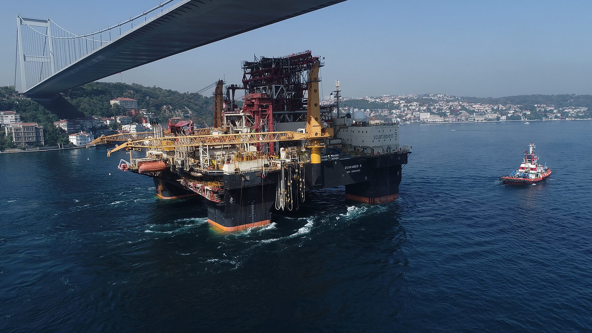 The semisubmersible drilling rig Scarabeo 9 sailing under a bridge on the Bosphorus Strait.