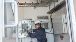 An employee performs onshore instrumentation and electrical work.