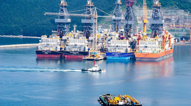 Tugboat sails past drill ships near the DSME shipyard in Okpo city, South Korea.