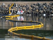 Crews deploy skimmers and booms to stop further incursion into the Wetlands Talbert Marsh in Huntington Beach, California, on Oct. 3, 2021.