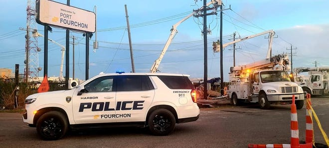 Power utility lineman work to restore power in Port Fourchon.