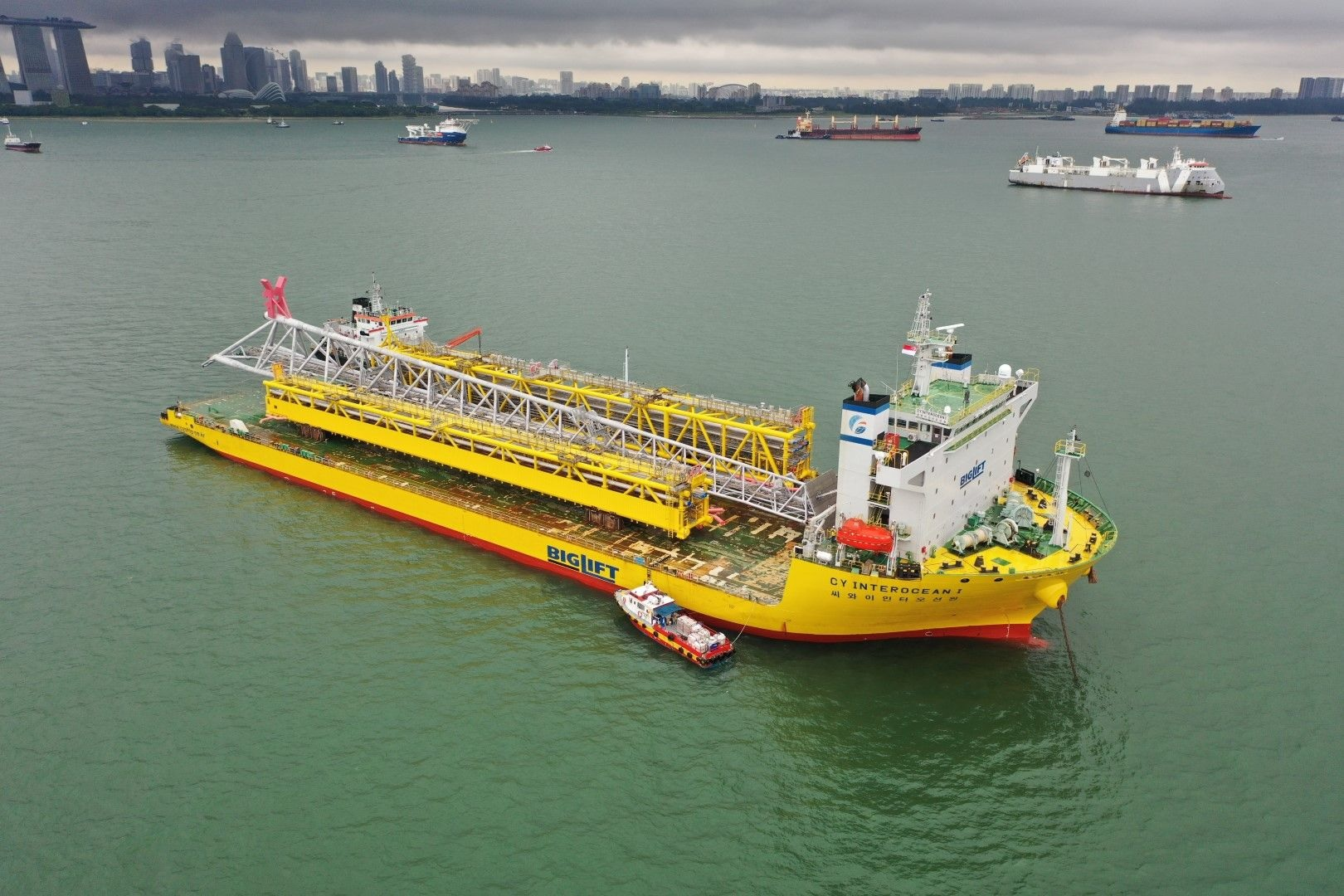 The CY Interocean I departing McDermott&rsquo;s Batam yard with the two bridges and a flare.
