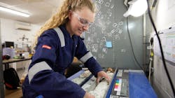 An employee prepares a sample for core logging. An employee prepares a sample for core logging.