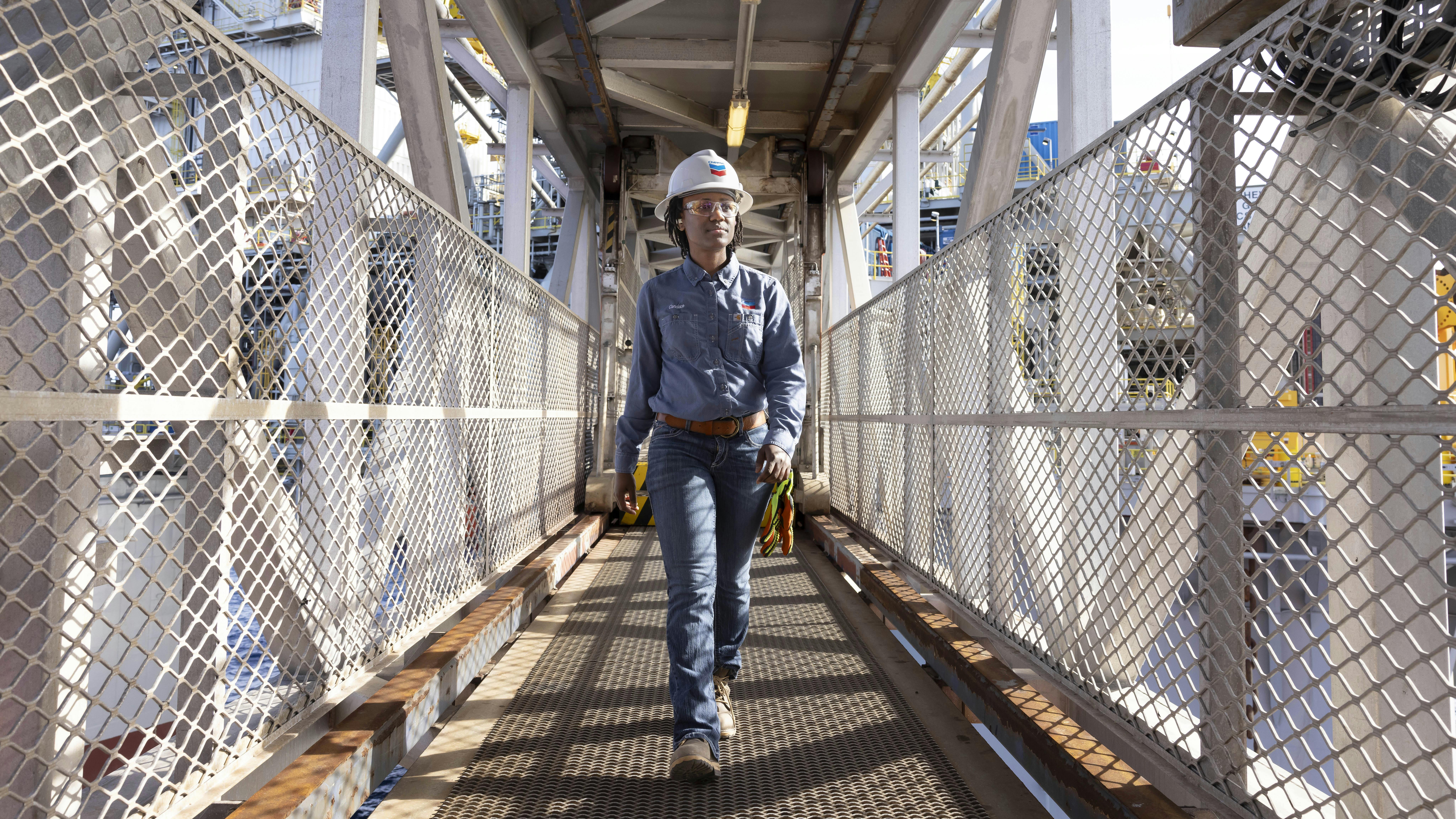 A worker walks along an offshore platform at Chevron's Anchor Field, a deepwater development with reservoir depths reaching 34,000 ft below the water surface.