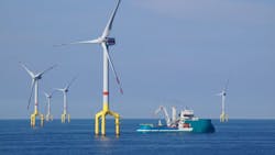 Offshore wind turbine with supply boat in the North Sea. Offshore wind turbine with supply boat in the North Sea.