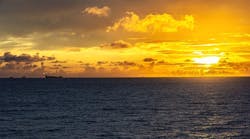 Offshore infrastructure, rig and an FPSO in the far distance offshore during sunset. Offshore infrastructure, rig and an FPSO in the far distance offshore during sunset.