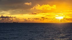Offshore infrastructure, rig and an FPSO in the far distance offshore during sunset. Offshore infrastructure, rig and an FPSO in the far distance offshore during sunset.