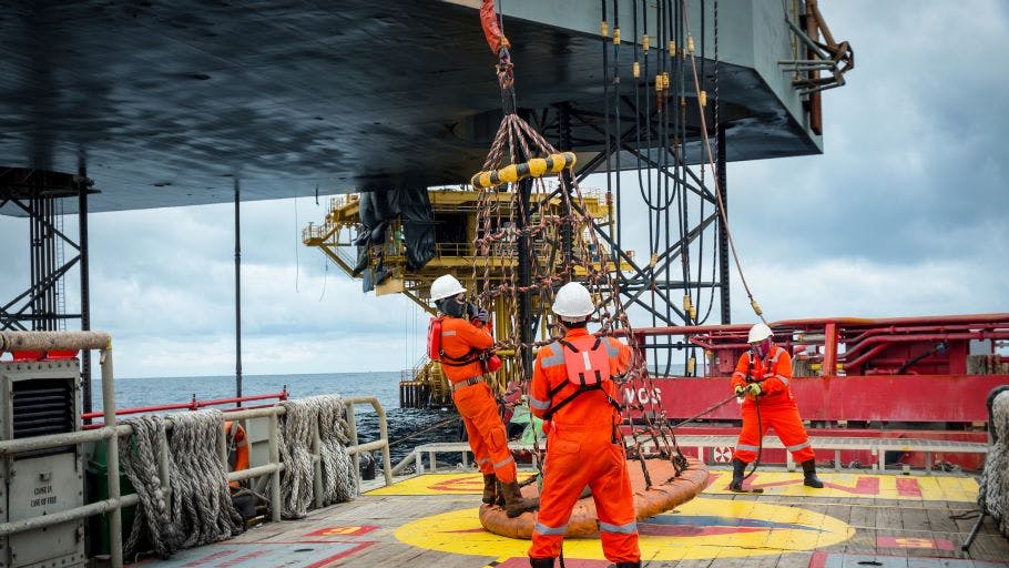 Personnel basket transfer from supply boat to offshore oil and gas rig.