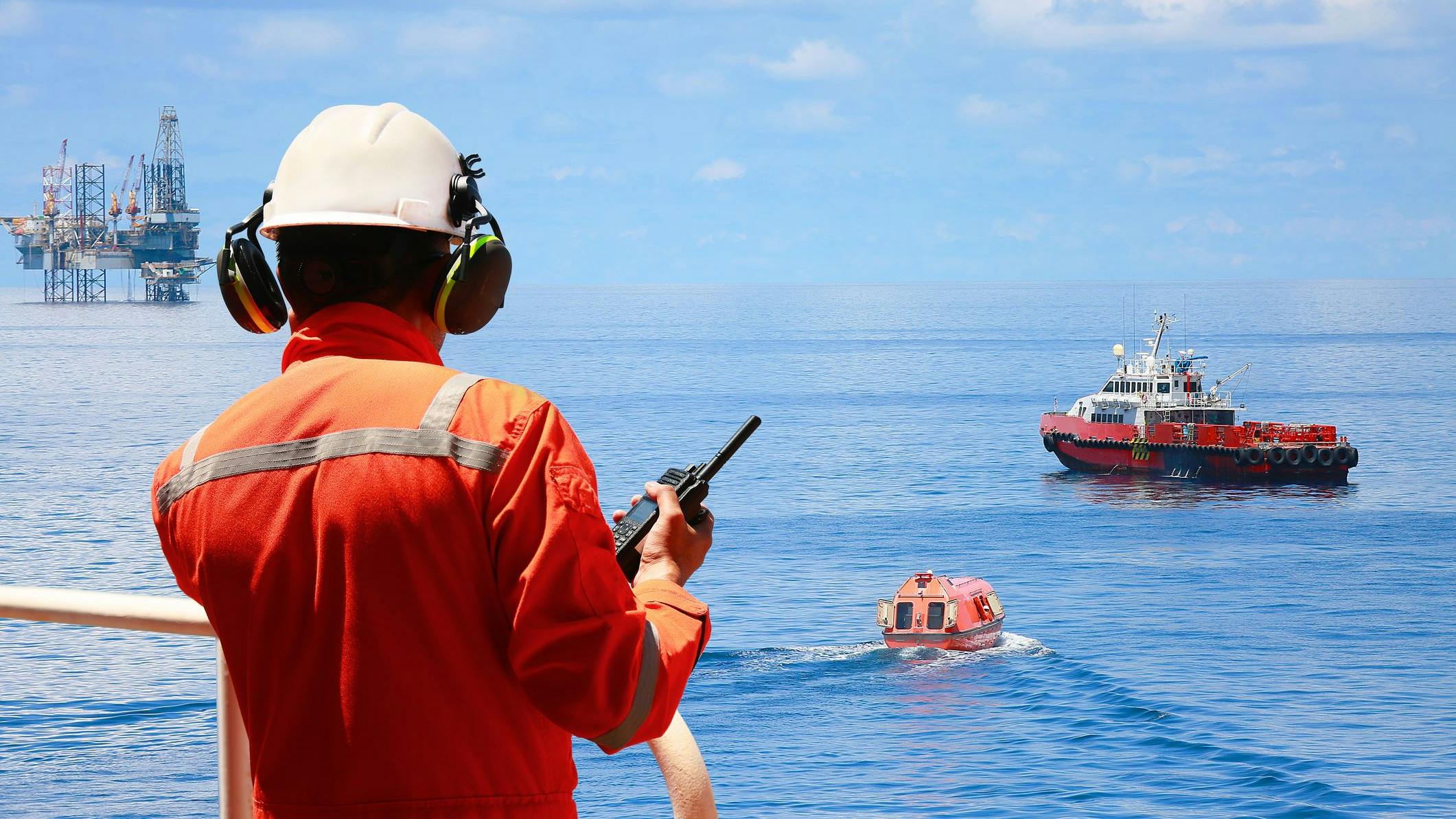 Worker in offshore oil and gas industry contacts operation team to check conditions