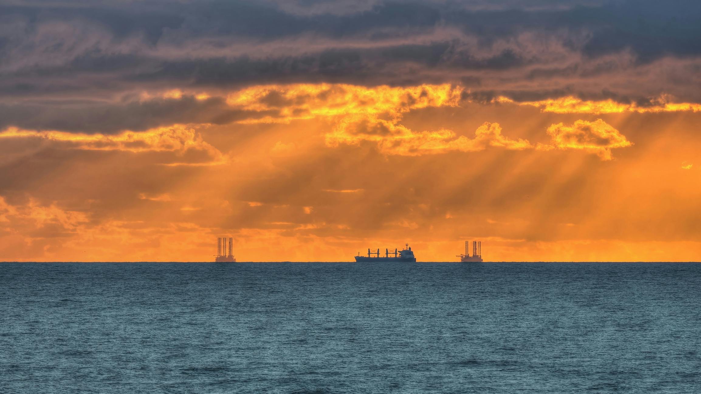 Offshore drilling rigs and a vessel in the Gulf of Mexico