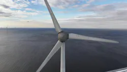Close-up aerial perspective of a wind turbine spinning over the ocean Close-up aerial perspective of a wind turbine spinning over the ocean