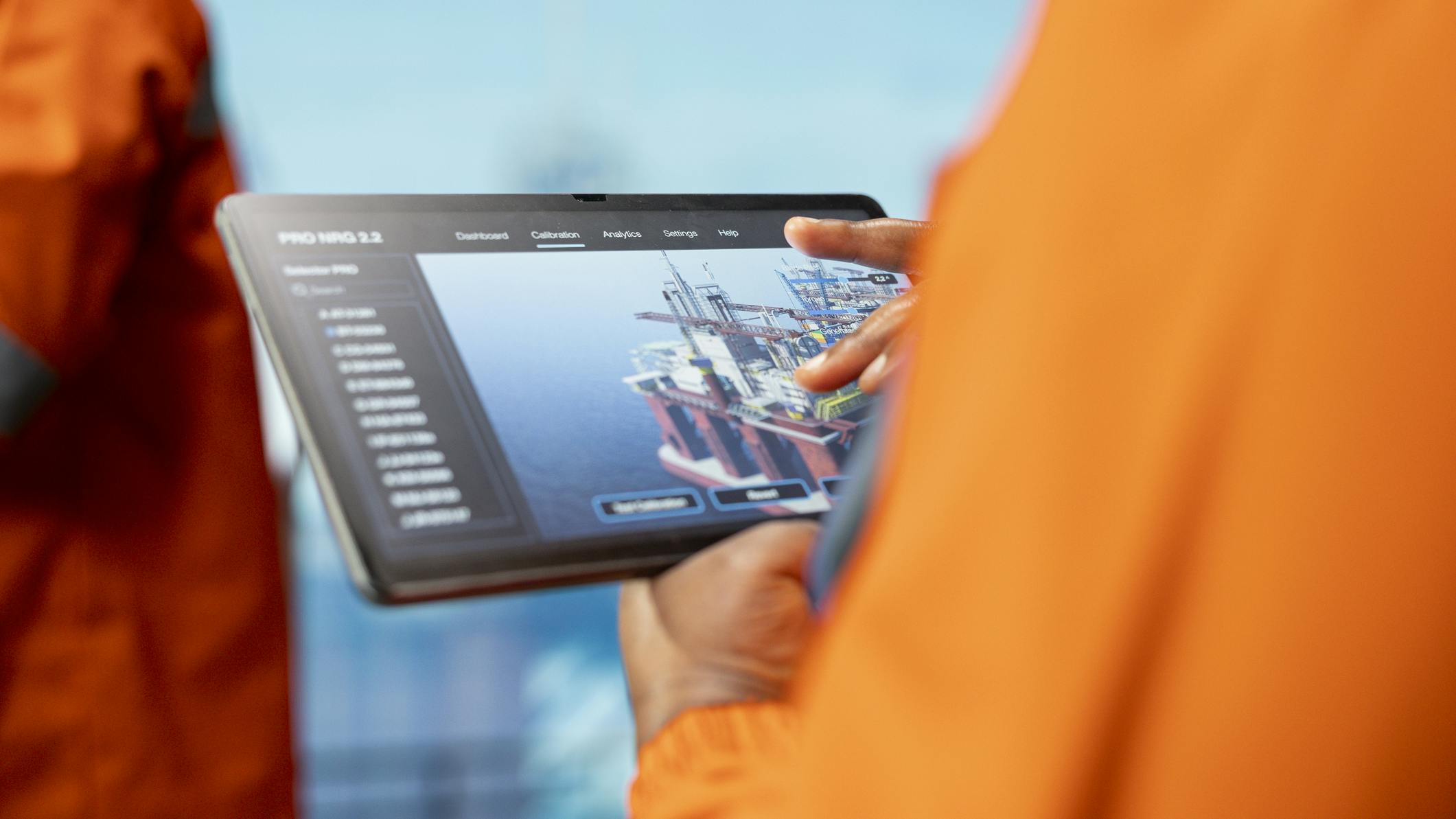 platform specialist uses a tablet to monitor real-time production data and performance metrics