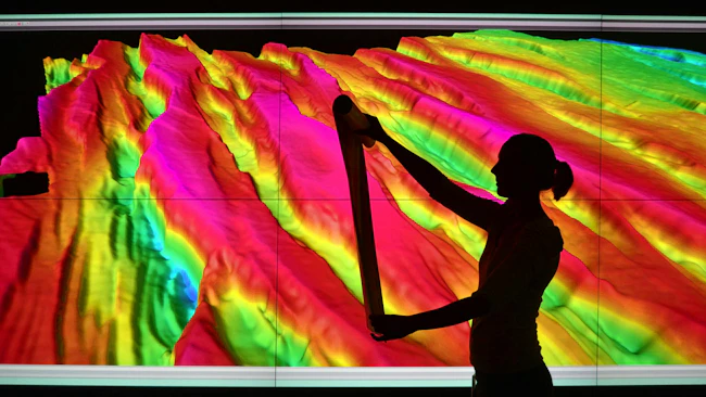 Female geoscientist examines print outs of seismic