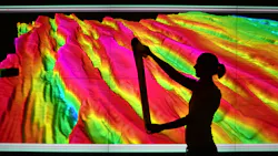 Female geoscientist examines print outs of seismic