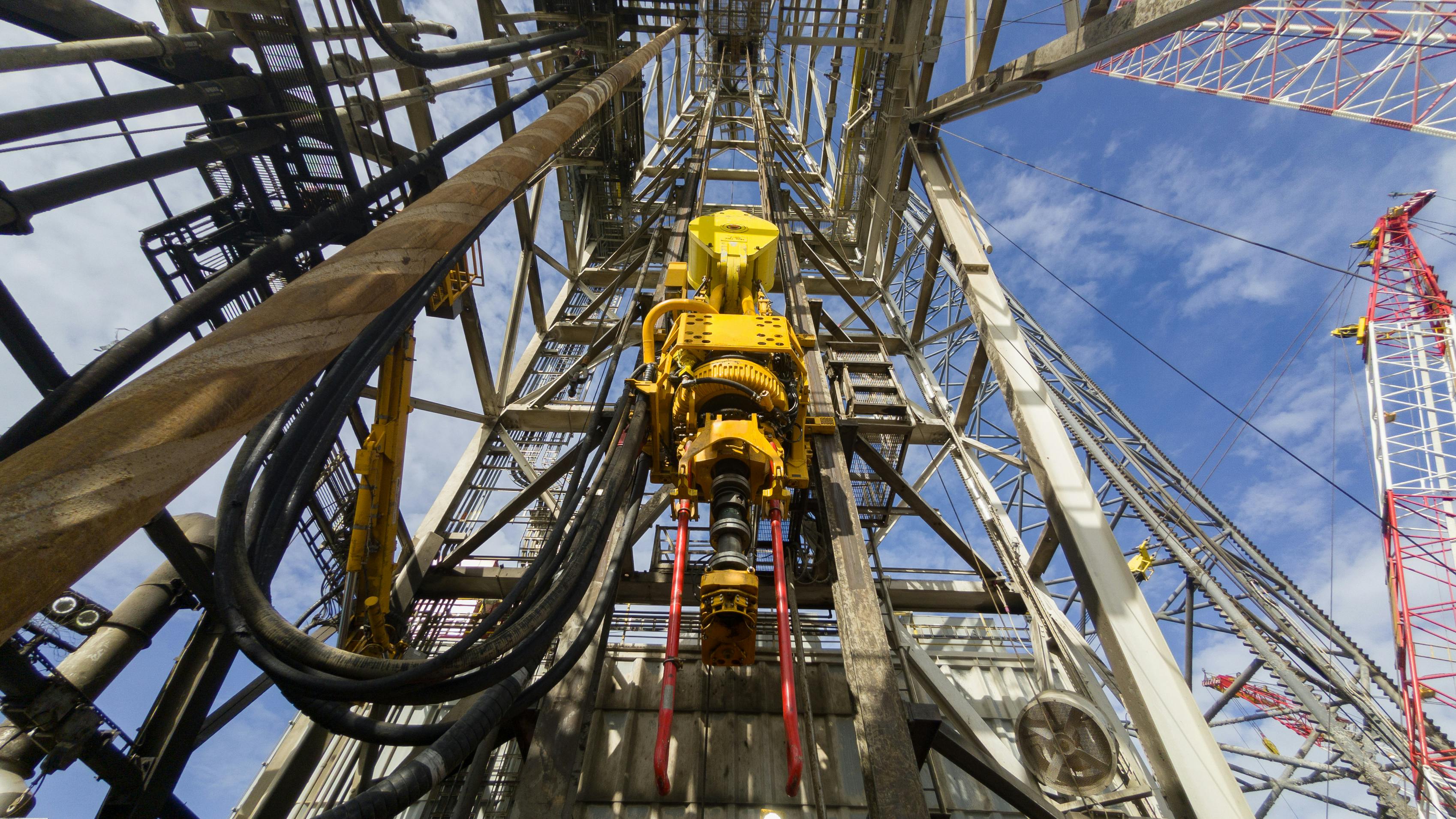 Driller floor of an offshore drilling rig with top drive, pipe handler and drawworks