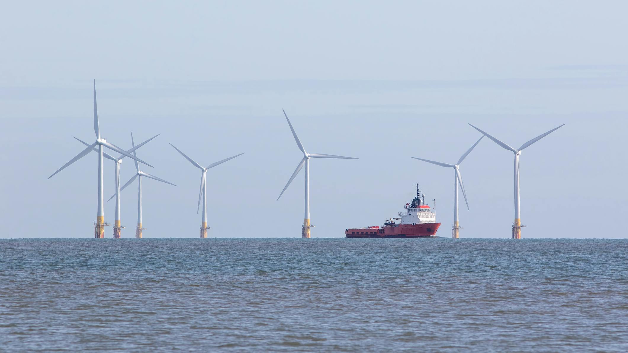 An offshore support vessel transits through a wind farm installation