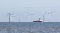 An offshore support vessel transits through a wind farm installation