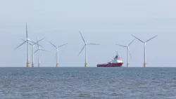 An offshore support vessel transits through a wind farm installation